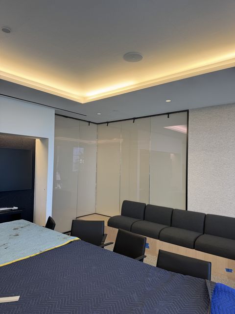 The same Santa Monica conference-room glass corner switched to frosted, milky white with faint shapes behind