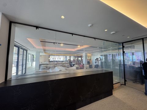 Santa Monica conference-room glass wall, return panels and door clear, with our crew working in the office fit-out beyond