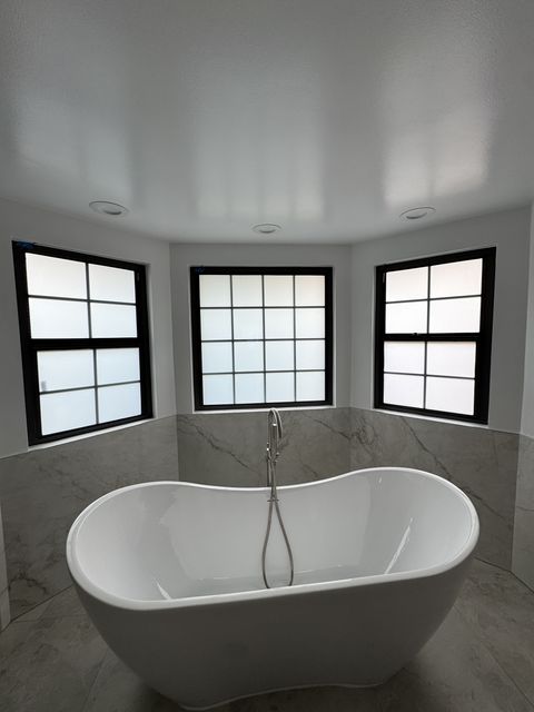Smart glass West Covina CA bathroom windows in frosted privacy mode above a freestanding tub