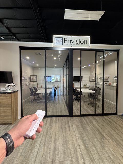 Hand pressing the wall switch that toggles privacy on a smart glass closets Woodland Hills display piece