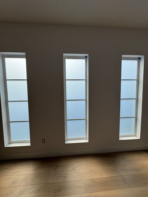 Smart glass windows Manhattan Beach — front door sidelight in clear state showing daylight view to street
