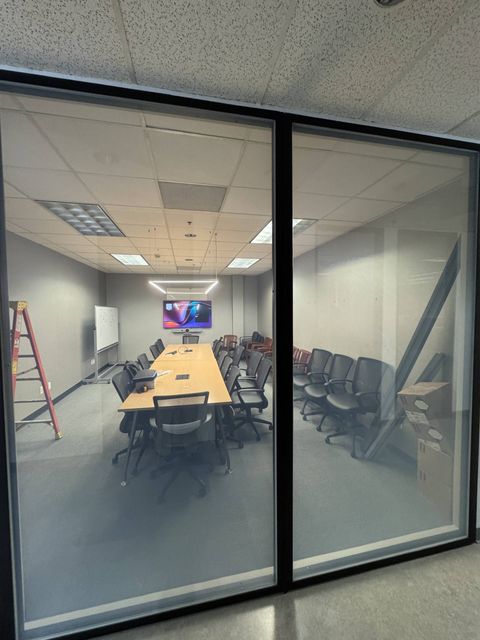 Hospital conference room in Westlake Village seen through its switchable glass wall powered clear, conference table and chairs fully visible