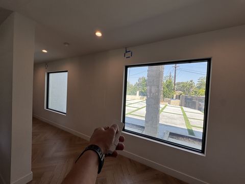 Smart glass windows Tarzana — picture window and clerestory in clear state showing street view with stone column outside