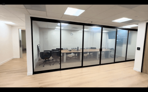 Switchable smart film on a glass-walled conference room demonstrating instant privacy spec for reconfigurable LA office floor plans