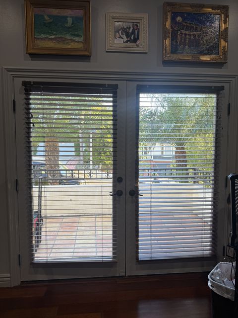 Before smart glass French doors Los Angeles install — original living room glazing with clear panels