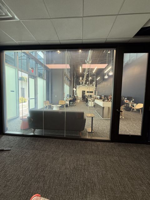 Smart glass LAX office Inglewood — multi-panel partition wall in frosted state separating lounge and office