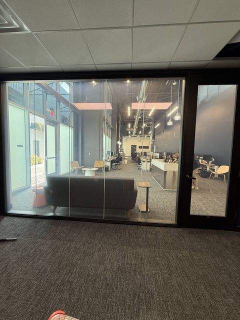 Five-panel switchable glass partition wall at an LAX-area office in Inglewood held clear, the open office fully visible through the glass