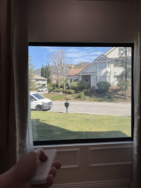 A window in a La Cañada Flintridge home with switchable smart film in clear mode, looking out to the street and hillside in daylight