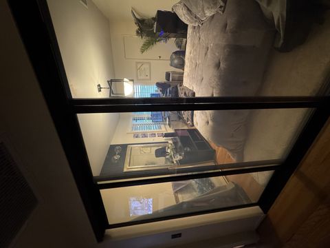 Real Smart View bedroom install in Pasadena: a black-framed switchable glass sliding partition in its clear state, showing the room beyond