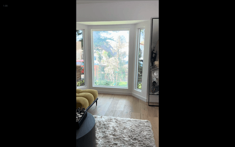 Large bay windows with a switchable smart film install in a modern LA living room demonstrating oversized-panel spec discipline