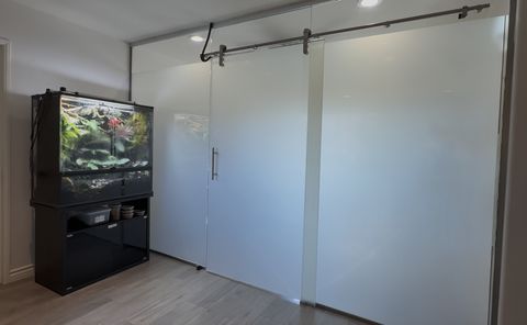 Smart glass study room Buena Park — frosted state of sliding glass door and walls fully private with aquarium visible