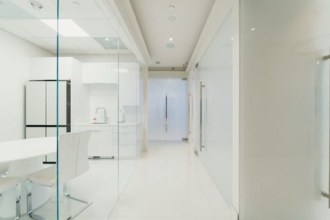 A real Smart View office install in Beverly Hills — clear glass partitions on one side and a frosted privacy glass door at the end of the corridor