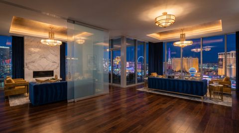 Las Vegas high-rise condo with a floor-to-ceiling clear switchable smart glass wall overlooking the Strip skyline at night