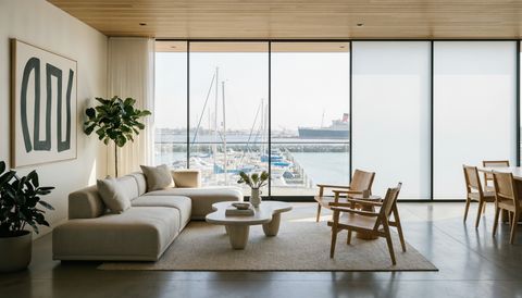 Long Beach waterfront condo with a floor-to-ceiling clear switchable smart glass wall overlooking the marina — several glass panels switched to frosted privacy mode