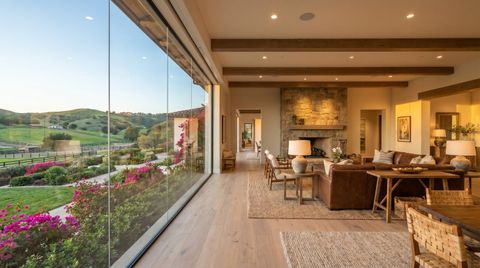 Rancho Santa Fe estate with a floor-to-ceiling clear switchable smart glass wall overlooking lush gardens and rolling hills