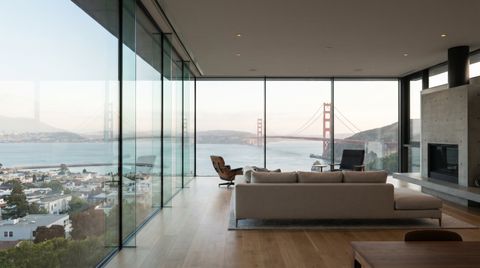 San Francisco home with a floor-to-ceiling clear switchable smart glass wall framing the Golden Gate Bridge and bay
