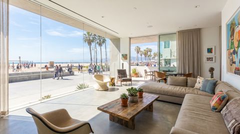 Venice Beach modern beach house with a floor-to-ceiling clear switchable smart glass wall overlooking the boardwalk and palms