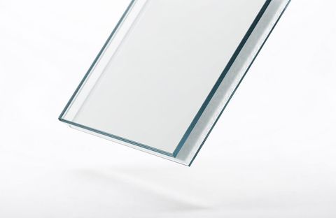 Macro of a laminated smart-glass panel edge — the switchable layer sealed flawlessly between two sheets of glass, no bubbles