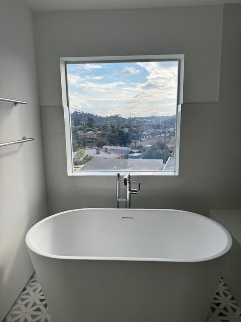 Modern LA residential bathroom window with switchable PDLC smart film retrofit demonstrating frosted-mode privacy as part of master-bath upgrade spec