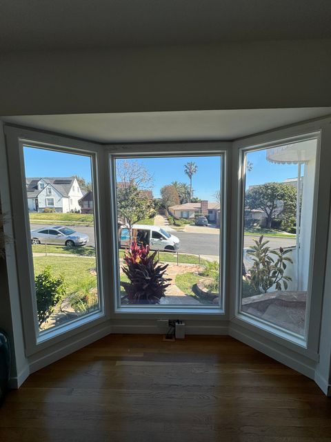 A Los Angeles bay window in the clear state, the street and neighboring homes visible through switchable glass