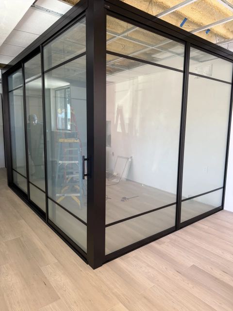 Real Smart View install: floor-to-ceiling switchable glass partitions dividing an open suite-style living space, shown clear