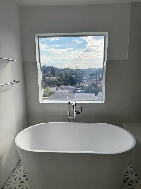 Smart glass bathroom window in Eagle Rock Los Angeles in clear mode above freestanding bathtub