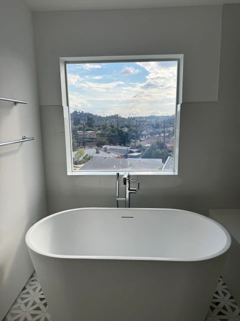 Smart glass bathroom window in Eagle Rock Los Angeles in clear mode above freestanding bathtub with city view