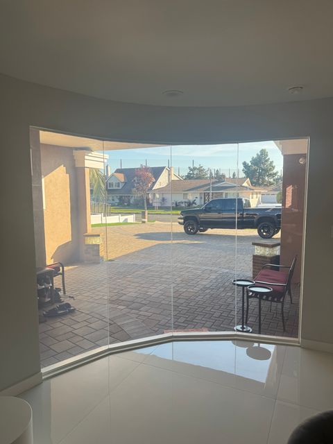 Clear-mode switchable PDLC smart film on a Malibu home window showing full daylight and unobstructed coastal views