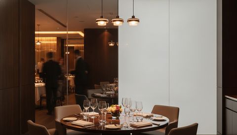 Illustration of a restaurant private dining room behind switchable smart glass — clear on one side, frosted for privacy on the other