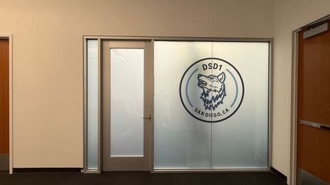 A frosted switchable glass office door in San Diego with a company logo cut into the glass