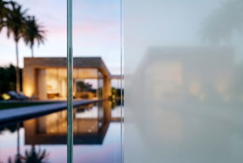 Macro close-up of switchable smart film on glass transitioning from clear on one side to milky frosted on the other