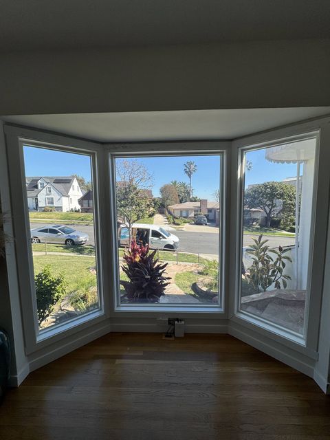 Street-facing living room bay window in Los Angeles with smart film switched clear, showing the full view of the street and front yard