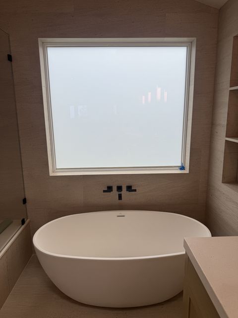 Smart film bathroom window in Laguna Beach frosted to an even milky white for full privacy above the freestanding tub