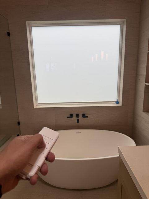 Smart View remote frosting the Laguna Beach bathroom picture window to solid white for instant bath privacy
