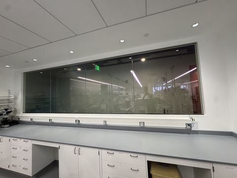 Inside the Los Angeles lab, the four-panel smart film observation window clear above the microscope bench