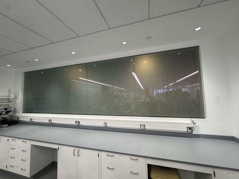 The same laboratory observation window from the lab side with all four smart film panels frosted to an even white