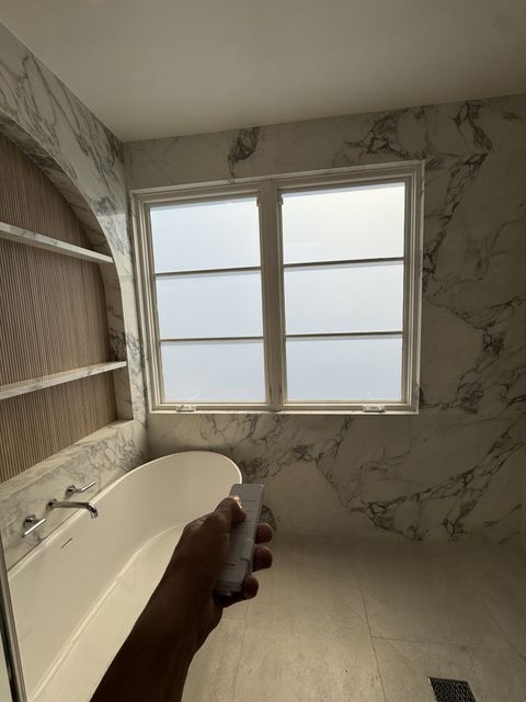 Smart View remote frosting the casement windows in a smart glass bathroom in Hermosa Beach for instant privacy