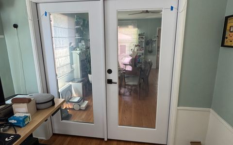 Smart glass French doors in a Burbank home office with the glass clear, looking through both panes into the dining room