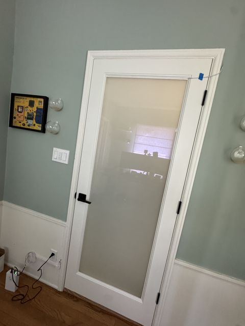 The same Burbank kitchen door with the smart glass in frosted privacy mode, still carrying kitchen daylight into the office