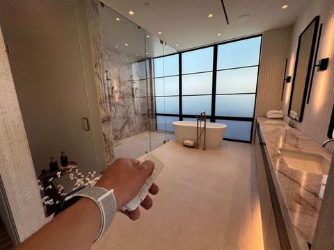 Hand holding the remote as the Newport Beach tub window switches to frosted