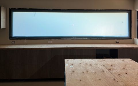 Smart glass kitchen Seal Beach — letterbox window in frosted state above lower cabinetry during construction