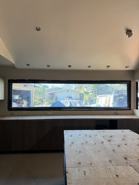 Smart glass kitchen Seal Beach — letterbox window in clear state showing street view across full length above lower cabinets
