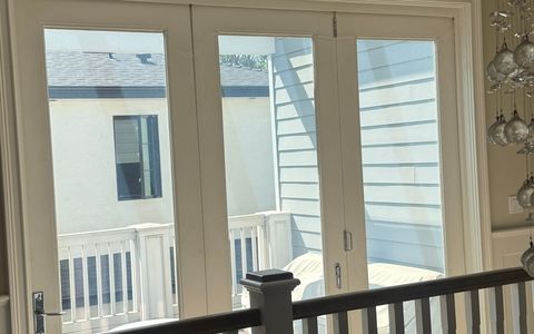 The finished smart glass bifold door in Studio City switched clear, all three panels looking through to the second-floor deck