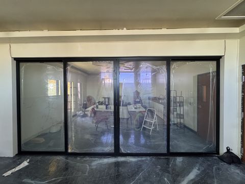 Four-panel sliding glass door wall at a Gardena office with the switchable film powered clear, the room beyond fully visible