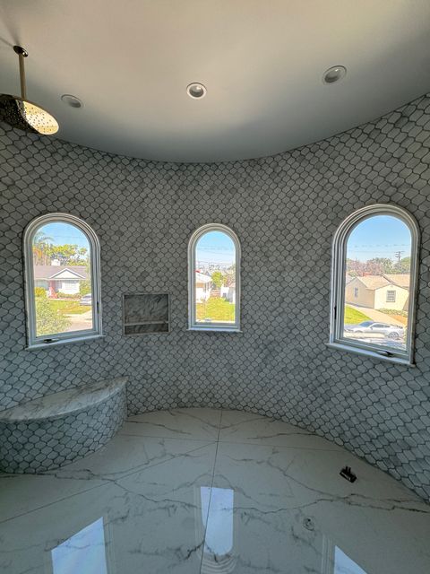 Marble bathroom with arched smart glass privacy windows in Torrance