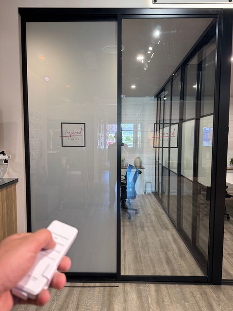 The same partition switched to frosted for privacy, with the wireless remote in hand