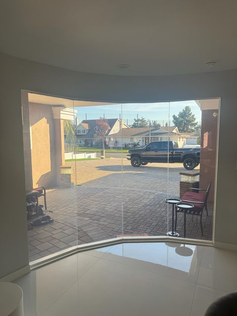 Large curved residential smart glass window in a modern luxury LA home showcasing high-end clarity and edge-to-edge install quality