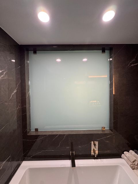 The same West Hollywood bath-to-bedroom glass wall switched to frosted opaque privacy