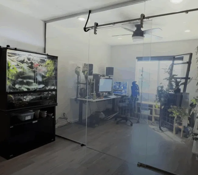 Home vs office smart glass — home office with large frameless smart glass sliding partition installed as a room divider