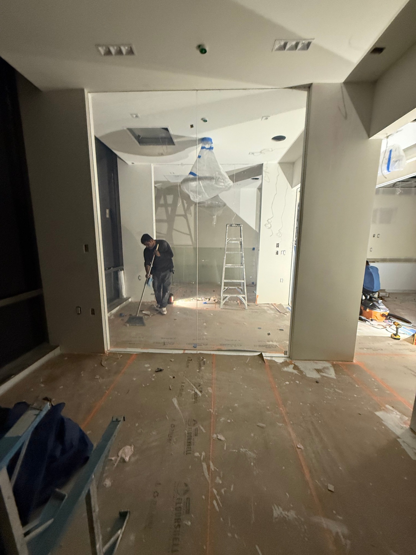 Commercial office smart film — switchable PDLC smart glass partition installation on a modern LA office under renovation, edge-to-edge frameless install